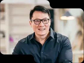 Smiling business professional in a smart navy shirt, with glasses, exuding expertise and approachability, reflective of the customer-focused service at our cryptocurrency exchange.