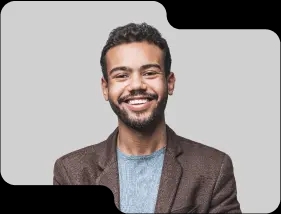 Enthusiastic young male team member with a friendly demeanor, wearing a brown blazer and light blue sweater, showcasing the dynamic and approachable team culture of our cryptocurrency exchange.